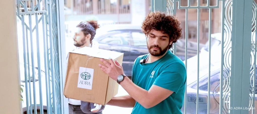 ADRA-Helfer tragen Kartons mit Hilfsgütern in eine Unterkunft für vertriebene Familien im Libanon.