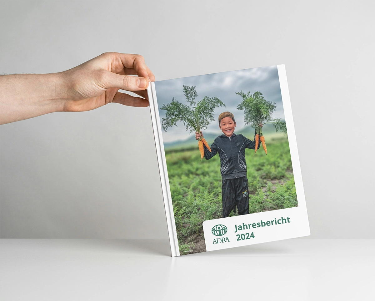 Junge aus der Mongolei zeigt fröhlich geerntete Karotten – ADRA Jahresbericht 2024