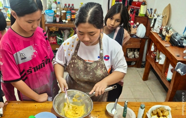 Mädchen nehmen in der ADRA-Schutzeinrichtung in Chiang Rai, Thailand, an einem Backworkshop teil und erwerben praktische Fähigkeiten für ihre Zukunft.