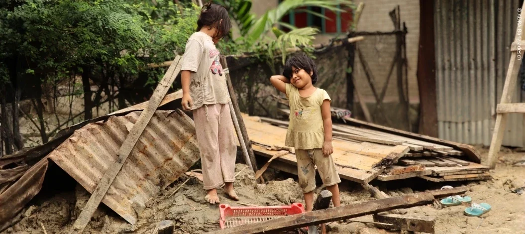Zwei Mädchen stehen zwischen Trümmern nach den schweren Überschwemmungen in Bangladesch