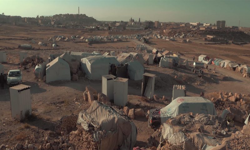 Eine Landschaft aus Zelten im Jemen. Im Hintergrund sieht man Gebäude und eine Moschee.