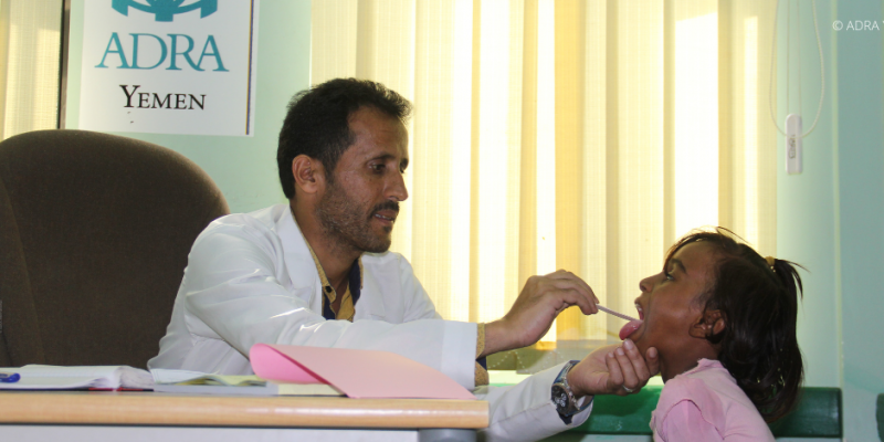 Arzt im Jemen untersucht den Hals eines Kindes in einer Praxis