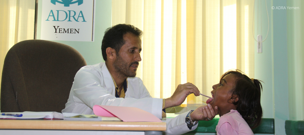 Arzt im Jemen untersucht den Hals eines Kindes in einer Praxis