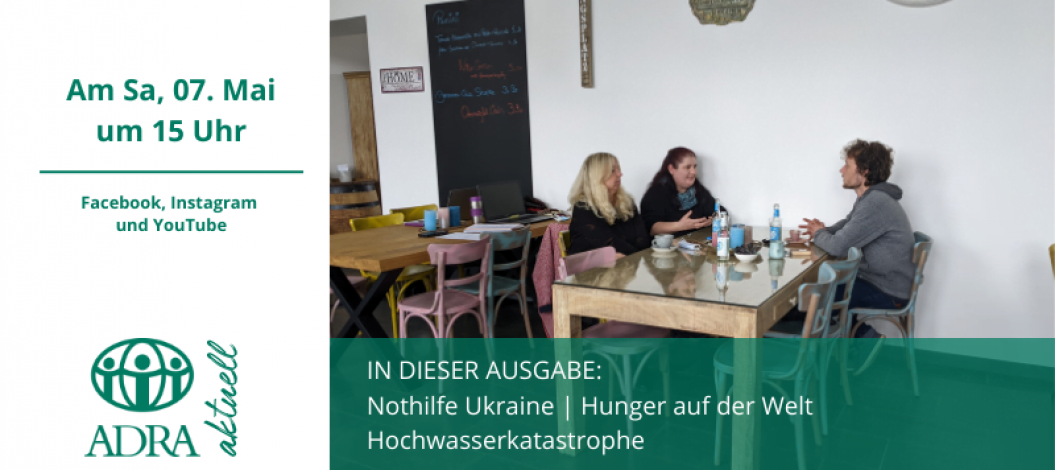 Drei Personen sitzen in einem Café an einem Tisch und unterhalten sich