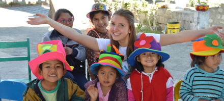ADRAlive!-Freiwillige Sophia in Peru hat Spaß mit den Kindern, die stolz bunte, selbstgebastelte Hüte tragen