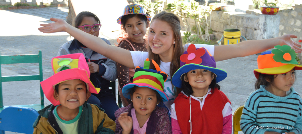 ADRAlive!-Freiwillige Sophia in Peru hat Spaß mit den Kindern, die stolz bunte, selbstgebastelte Hüte tragen