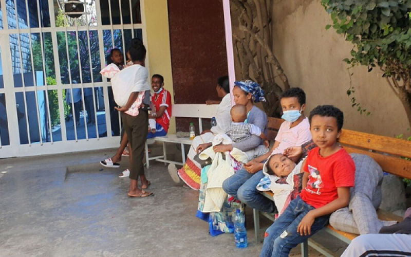 Eltern warten mit ihren Kindern auf den Arm im Außenbereich einer Kinderklink