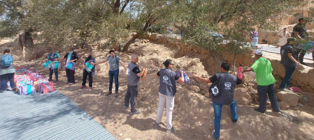 ADRA-Helfer bilden eine Menschenkette, um Hilfspakete in einem trockenen, bewaldeten Gebiet weiterzureichen