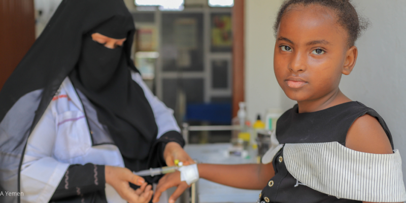 Mädchen im Jemen erhält eine Injektion in die Hand, Symbol für die Bedeutung von Gesundheit als kostbarstes Gut