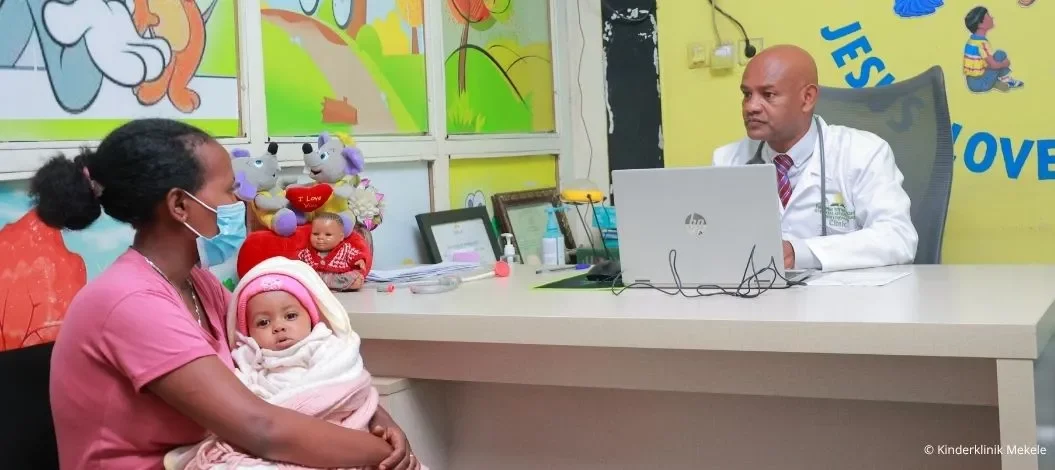 Ausbaau der Kinderklinik in Mekele - Arzt der Kinderklinik Mekele in Äthiopien untersucht ein Kind, das von seiner Mutter gehalten wird.