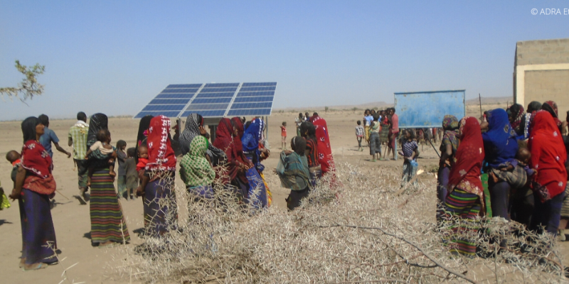 Eine Gruppe von Einwohnern in Äthiopien steht im Freien und bewundert die fertiggebaute Solaranlage.