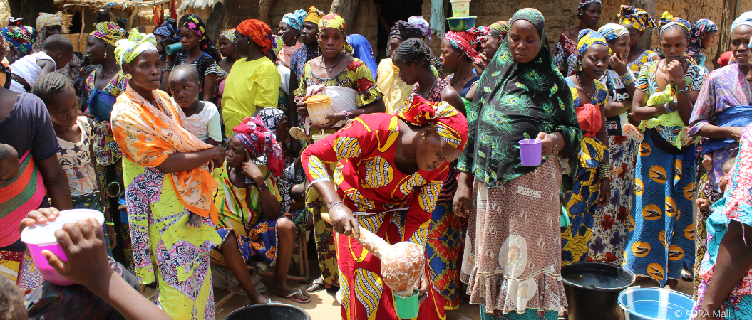 Frauen und Kinder in Togo kochen gemeinsam im Freien mit traditionellen Methoden