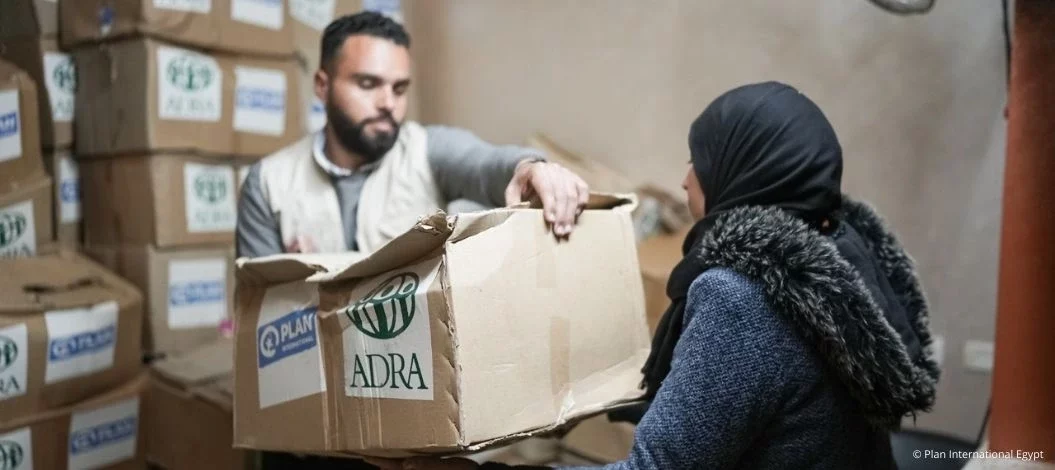 Hilfsgüterverteilung: Ein Helfer übergibt einer Frau ein ADRA-Paket in einem Lagerraum in Gaza.