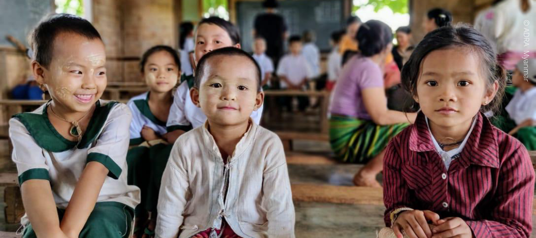 Gemeinsam eine bessere Welt durch Bildung schaffen: Eine junge Schulklasse in Myanmar in weiß-grünen Uniformen.