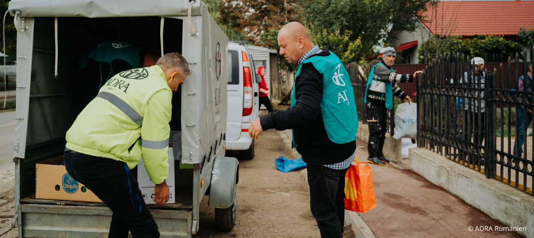 ADRA-Helfer entladen Hilfspakete aus einem Transporter in einer vom Hochwasser betroffenen Region in Mittel- und Osteuropa. Die Pakete enthalten lebensnotwendige Güter wie Lebensmittel, Hygieneartikel und Decken, um den Betroffenen schnelle Unterstützung zu bieten.