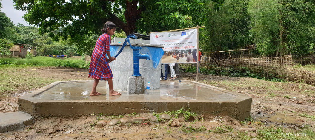 Ein indisches Mädchen füllt vor einer Wasseraufbereitungsanlage sauberes Trinkwasser in eine Flasche