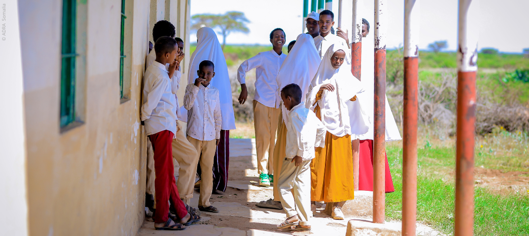 Gruppe somalischer Schüler in Uniform, lachend im Freien – Symbol für erfolgreiche Bildungsinitiativen in Krisengebieten.