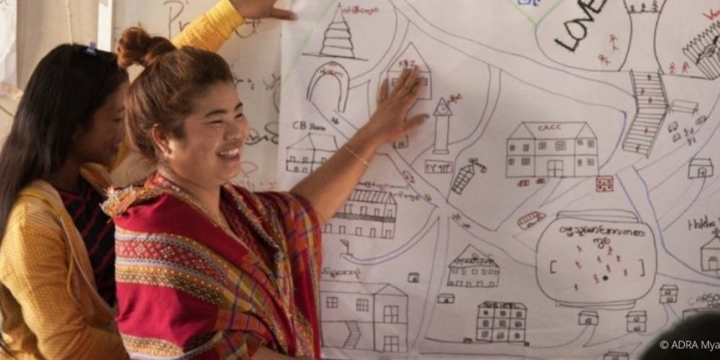 Zwei Lehrerinnen stehen lächelnd vor einem Whiteboard