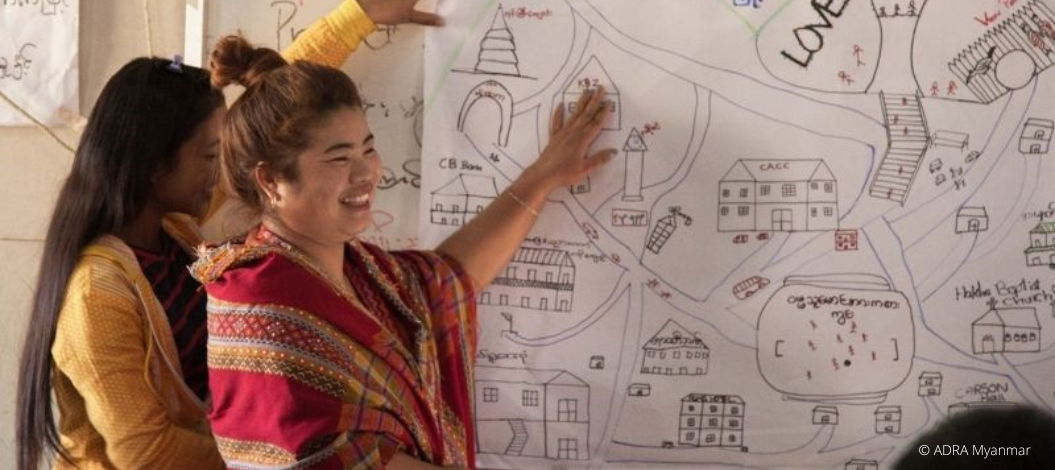 Zwei Lehrerinnen stehen lächelnd vor einem Whiteboard