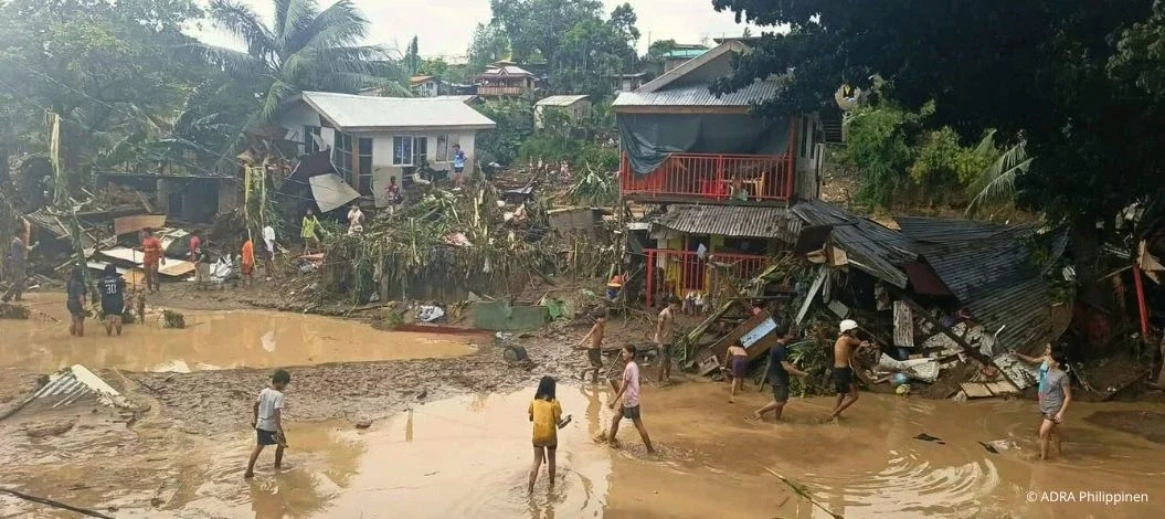 Nothilfe Taifun Kalmaegi Philippinen Vietnam – zerstörte Häuser und überflutete Straßen nach dem Tropensturm, Menschen waten durch Schlamm und Trümmer