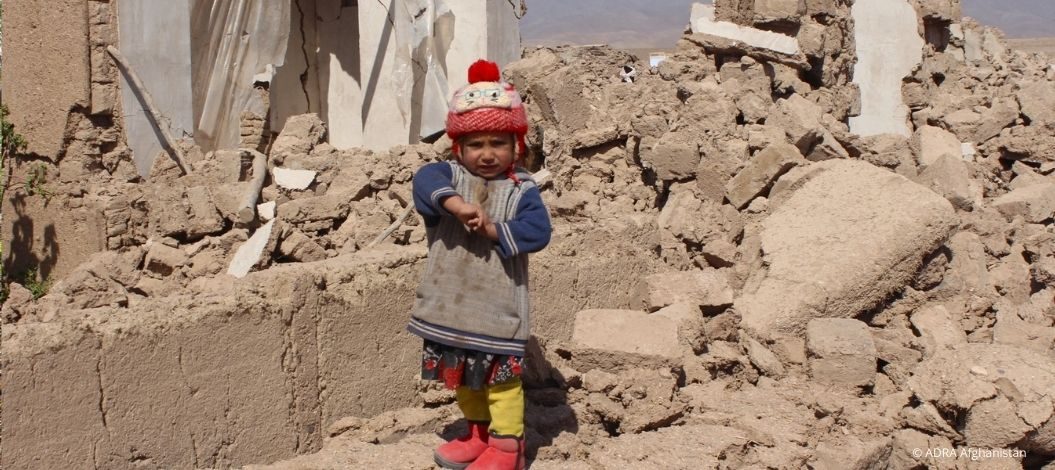 Kleines Kind steht in den Trümmern eines eingestürzten Hauses nach dem Erdbeben in Afghanistan, Symbolfoto für die Katastrophe