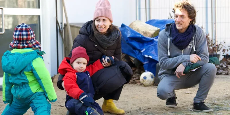 Ein ADRA-Mitarbeiter zusammen mit einer Dame und zwei Kindern in der Kita Löwenherz nach dem Wiederaufbau der Flutkatastrophe.