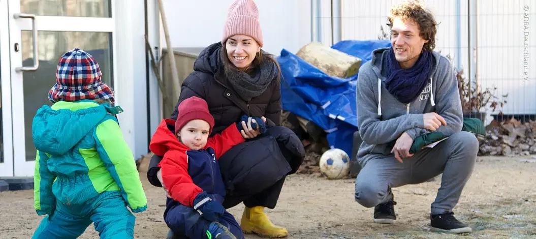 Ein ADRA-Mitarbeiter zusammen mit einer Dame und zwei Kindern in der Kita Löwenherz nach dem Wiederaufbau der Flutkatastrophe.