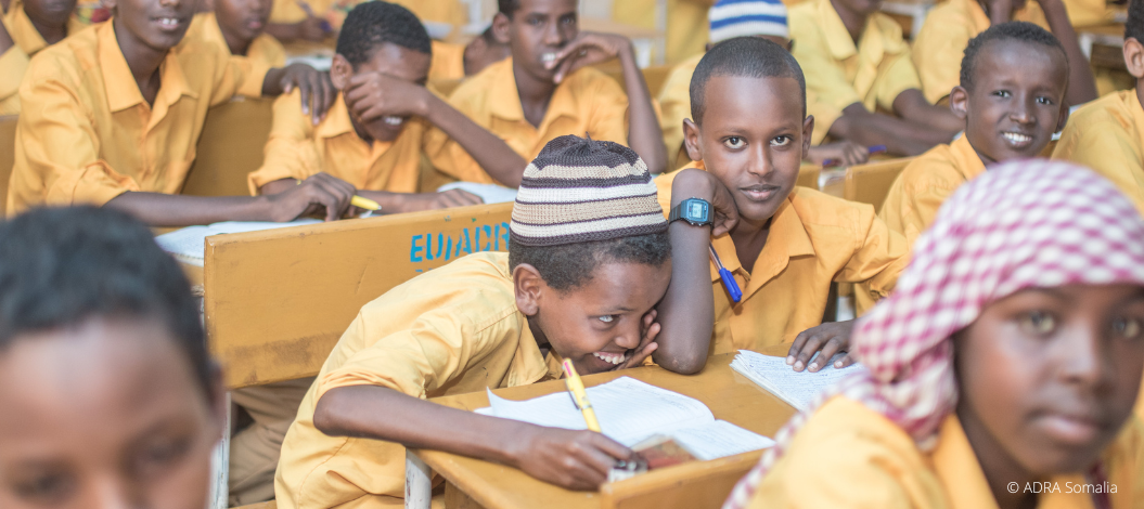 Eine Schulklasse bestehend aus Jungen in gelber Schuluniform sitzt im Klassenraum
