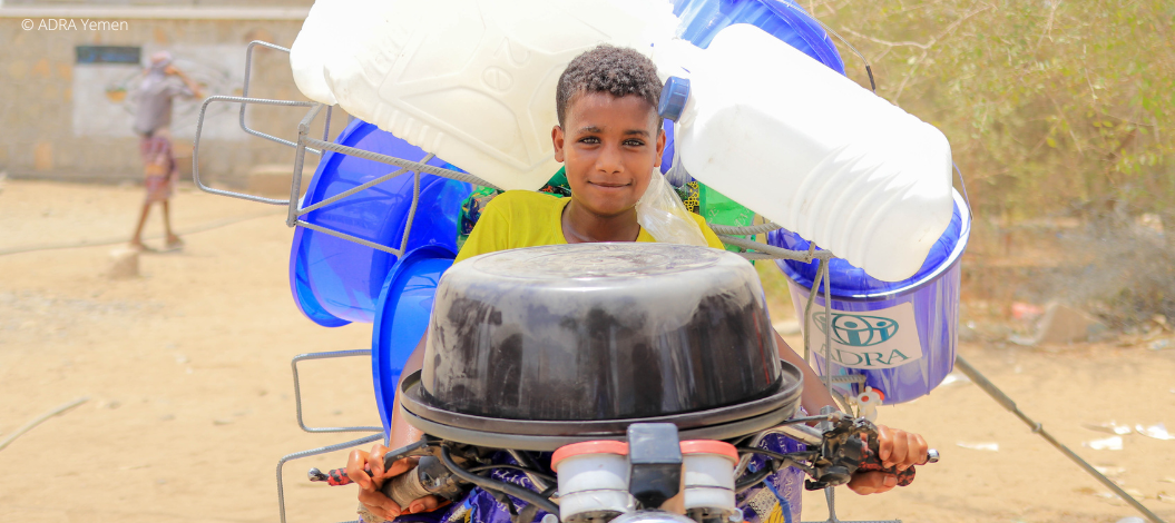 Ein Junge auf einem mit Kanistern vollgepacktem Motorrad im Jemen
