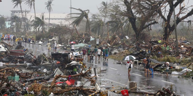 Anwohner gehen auf einer Straße, die mit Trümmern übersät ist, nachdem der Super-Taifun Haiyan die Stadt Tacloban im Zentrum der Philippinen am 10. November 2013 verwüstet hat.