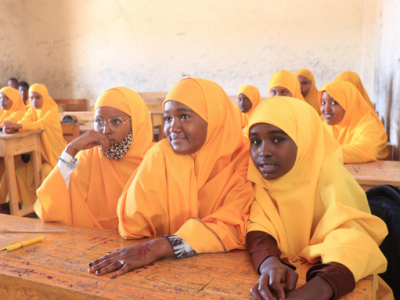 Eine Gruppe von Schülern in gelber Uniform im Klassenzimmer während des Unterrichts.