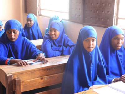 Schulmädchen in blauer Schuluniform mit Kopfbedeckung, während des Unterrichts in Somalia.