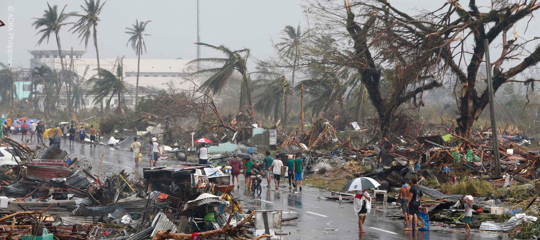 Anwohner gehen auf einer Straße, die mit Trümmern übersät ist, nachdem der Super-Taifun Haiyan die Stadt Tacloban im Zentrum der Philippinen am 10. November 2013 verwüstet hat.