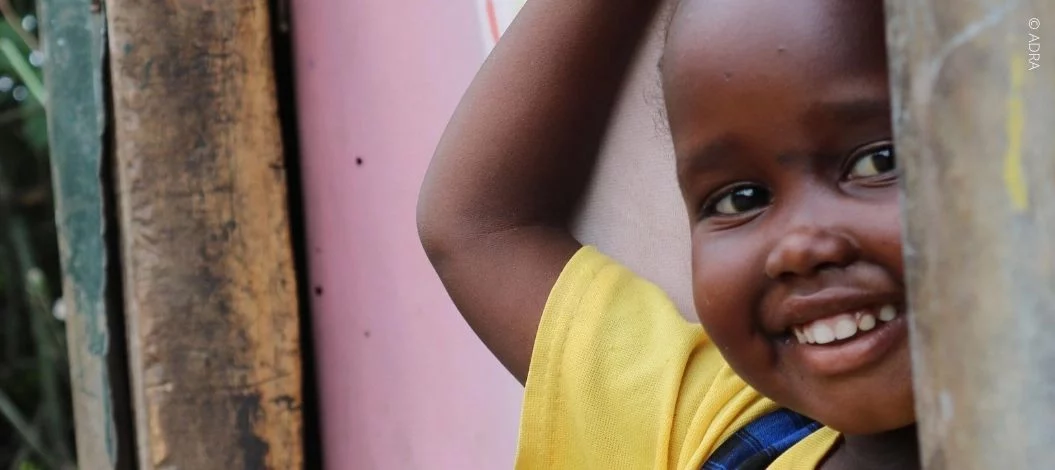 Ein Junges Mädchen schaut und lächelt in die Kamera