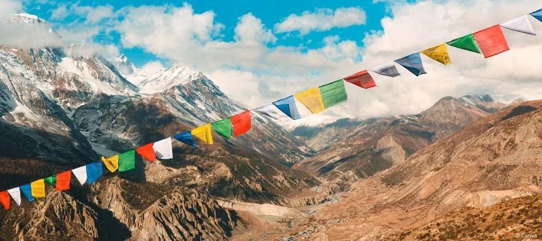 Berglandschaft im Himalaya in Nepal mit bunten Gebetsfahnen im Vordergrund.